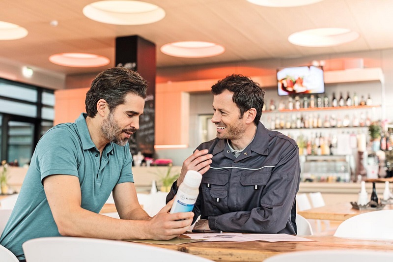 En skadedyrsbekæmper og hans kunde har en samtale i en restaurant