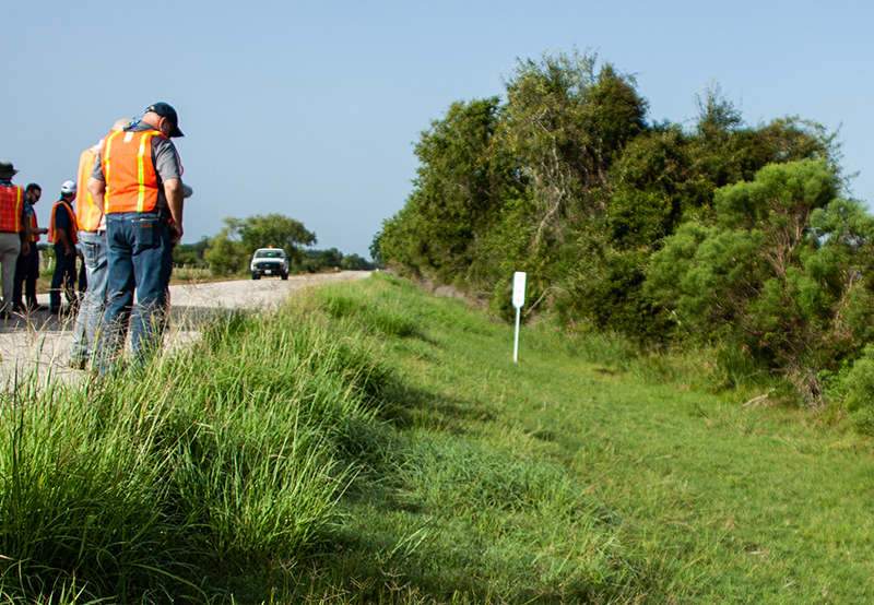 men wearing safety vests standing on the roadside